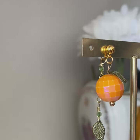 Un bijou vitaminé signé Mieleonor. Boucles disco orange - acier inoxydable, une pièce éclatante en acier inoxydable inspirée de vos journées et du plaisir de briller.